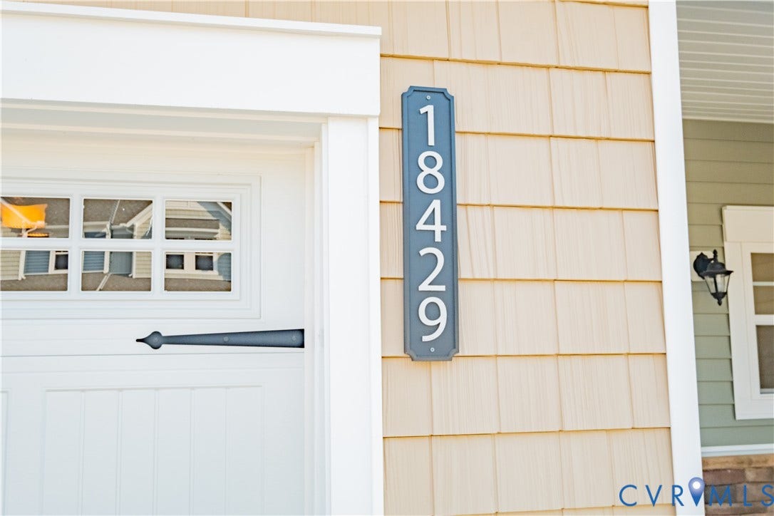 18429 Palisades Court, Chesterfield, VA 23120 White garage door with window inserts and decorative black hardware, framed by white trim