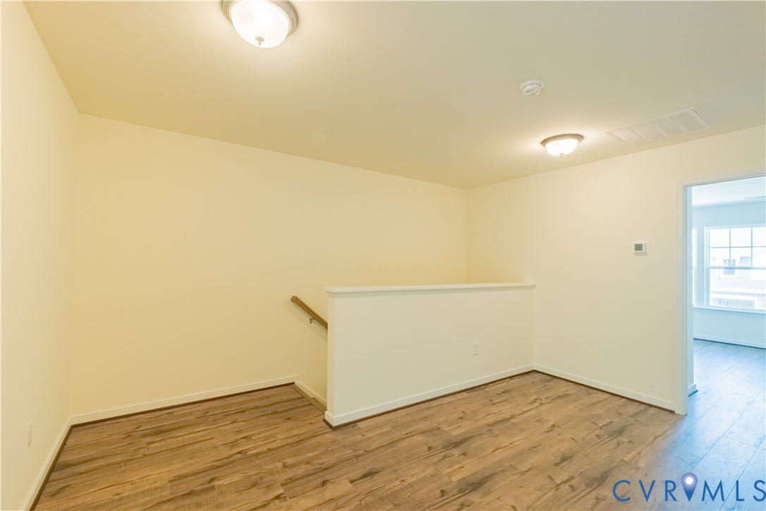 18429 Palisades Court, Chesterfield, VA 23120 Upper-level landing featuring wood-finish flooring, light-toned walls, a white half-wall railing, and a natural wood handrail