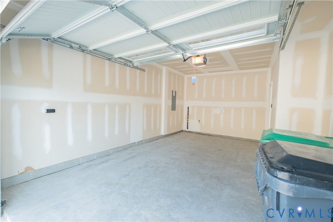 18429 Palisades Court, Chesterfield, VA 23120 Spacious garage featuring a concrete floor, unpainted drywall walls, and an automatic garage door opener