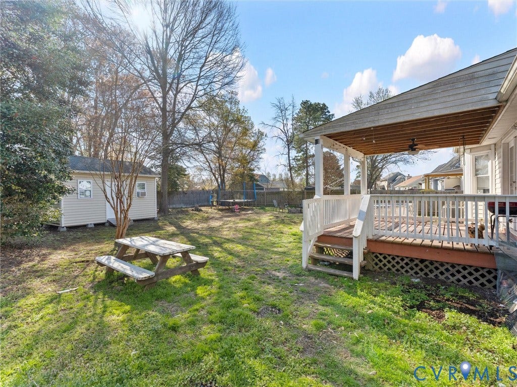 7323 Pineleaf Drive, Chesterfield, VA 23234 Expansive backyard featuring a covered porch with a ceiling fan, a detached storage shed, a manicured lawn, and mature trees