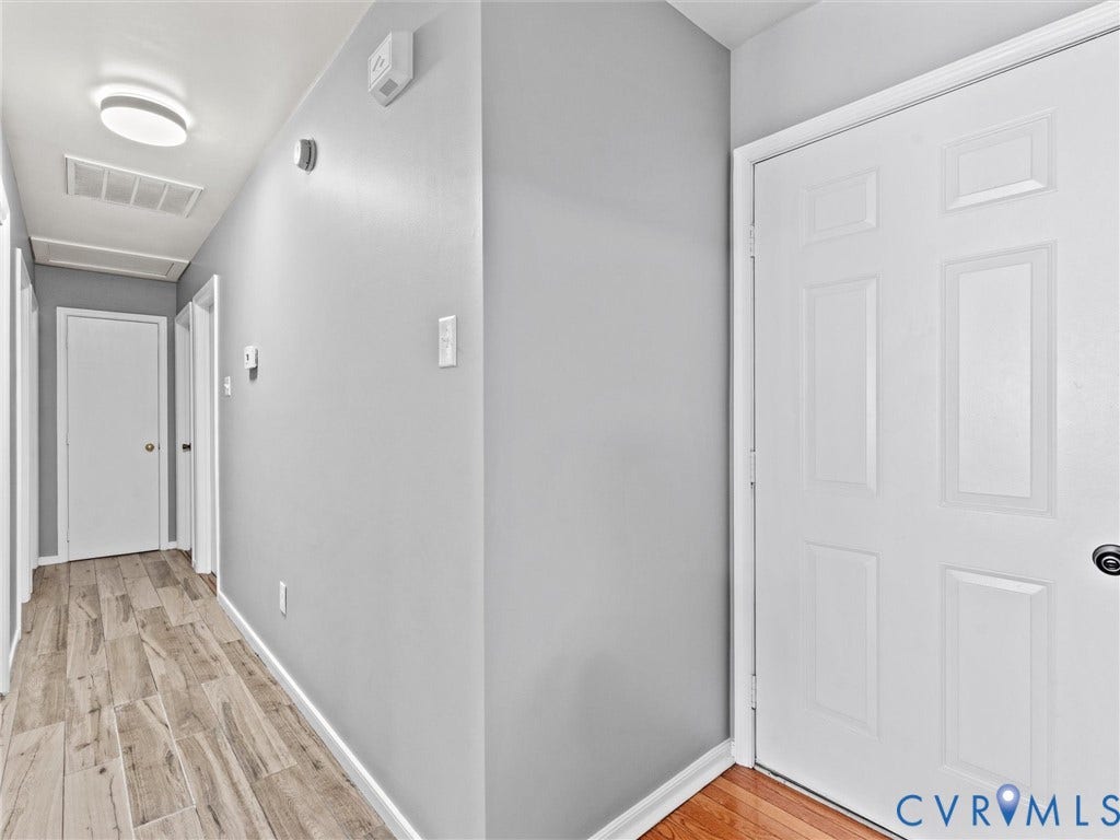 7323 Pineleaf Drive, Chesterfield, VA 23234 Hallway featuring light gray walls, wood-finish flooring, white trim, and white paneled doors