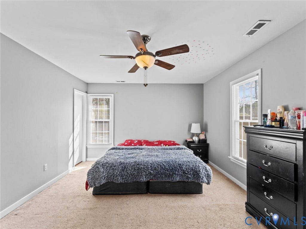 7323 Pineleaf Drive, Chesterfield, VA 23234 Carpeted room featuring light gray walls, a ceiling fan with integrated lighting, and two windows with white trim