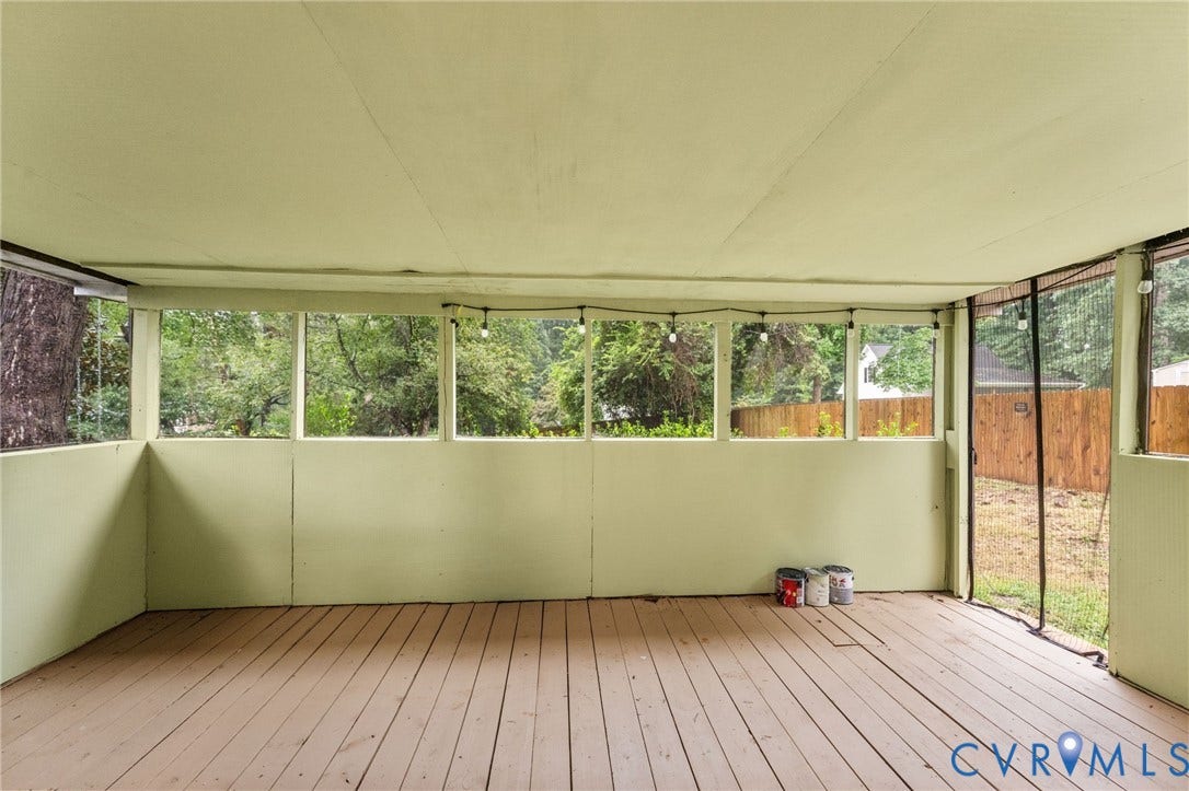 Screened-in porch featuring wood-finish flooring, half-wall enclosures, and integrated string lighting