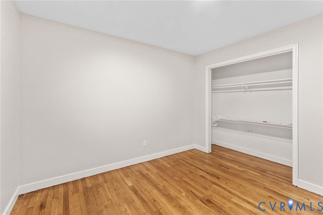 Room featuring wood-finish flooring, white baseboards, and light-toned walls