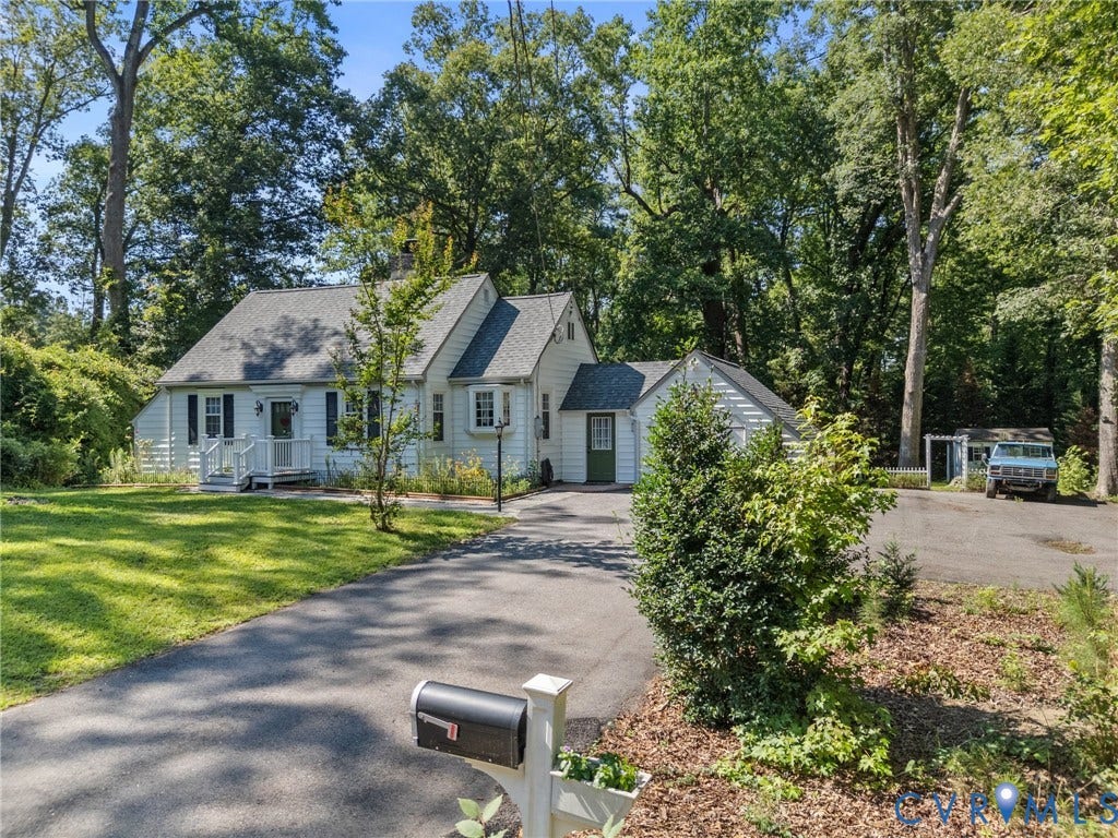 White siding home featuring a front porch, bay window, and gabled roofline