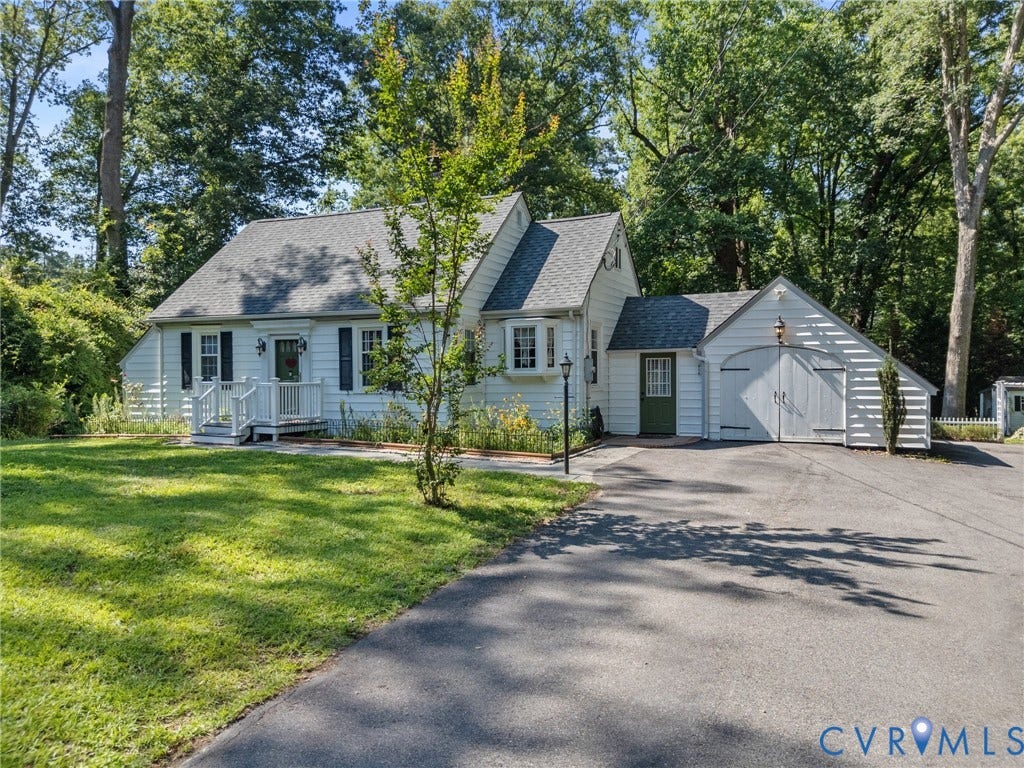 Charming white siding residence with dark shutters and a welcoming front porch