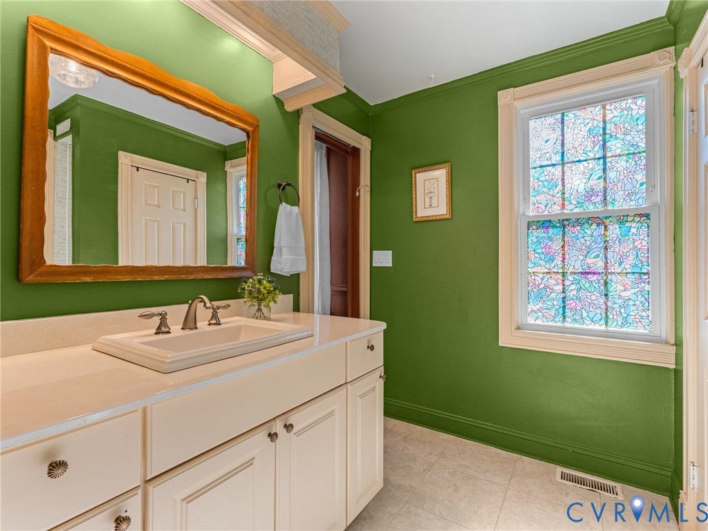 Bathroom vanity with an integrated sink, brushed nickel faucet, and a light-colored countertop