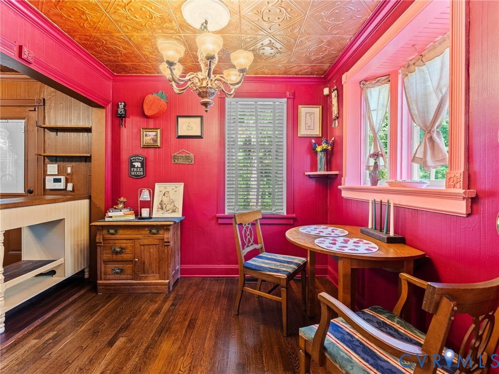 Distinguished dining area featuring a decorative tin ceiling, wood-finish flooring, and a chandelier light fixture