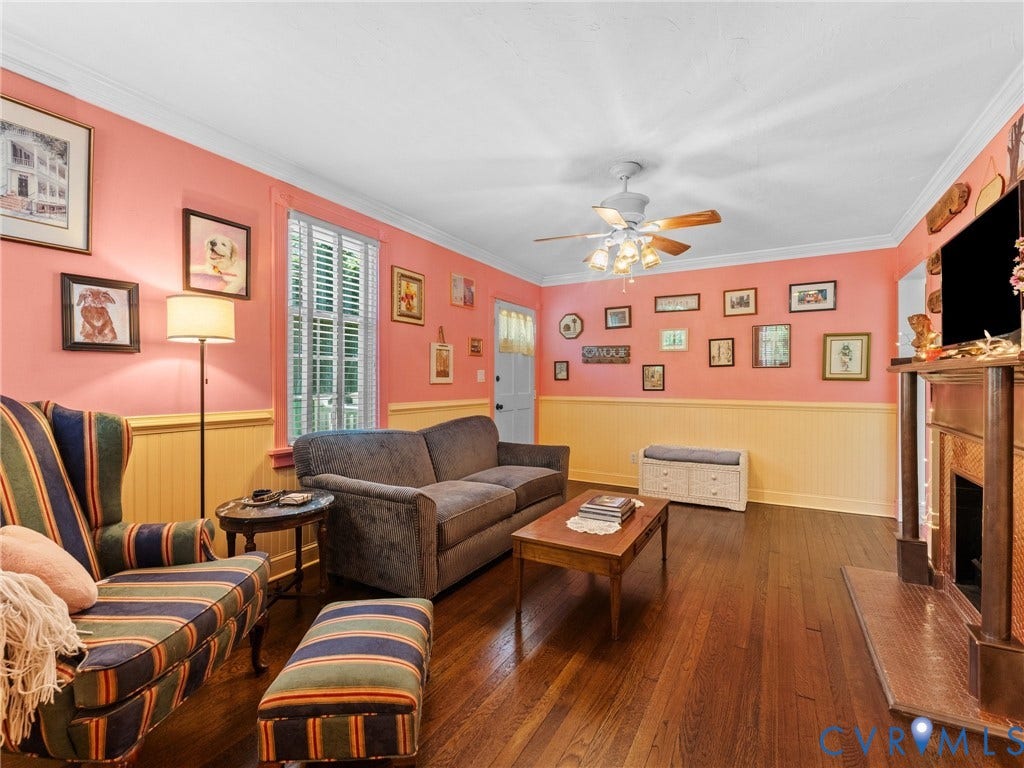 Living area featuring wood-finish flooring, wainscoting, and crown molding