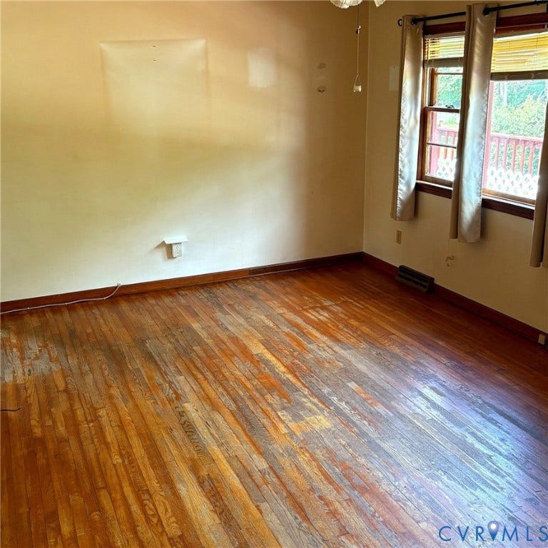 Hardwood flooring throughout, featuring baseboard trim and multiple windows