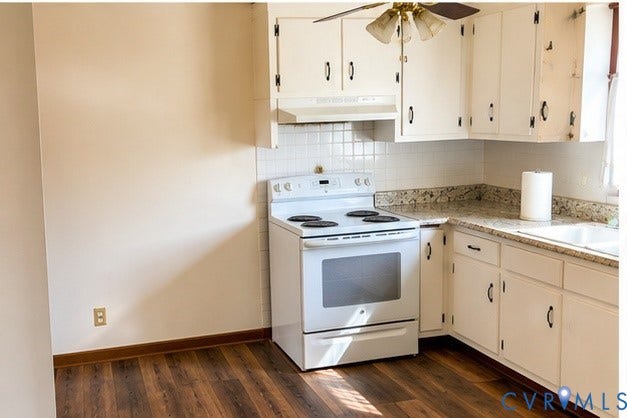 Kitchen featuring white cabinetry with dark hardware, a white electric range, and light-colored patterned countertops