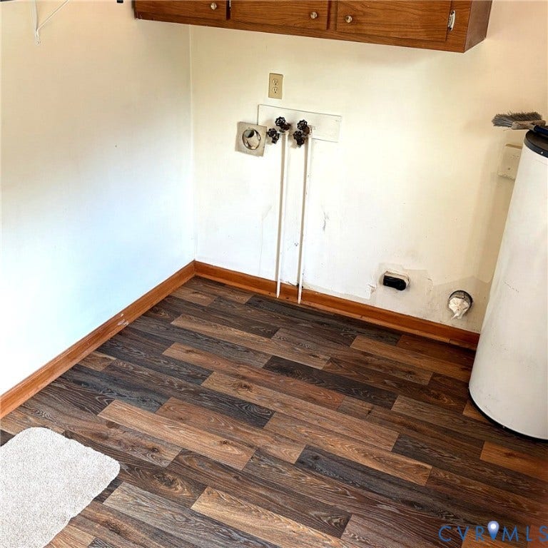 Laundry area featuring wood-finish flooring, and built-in cabinetry