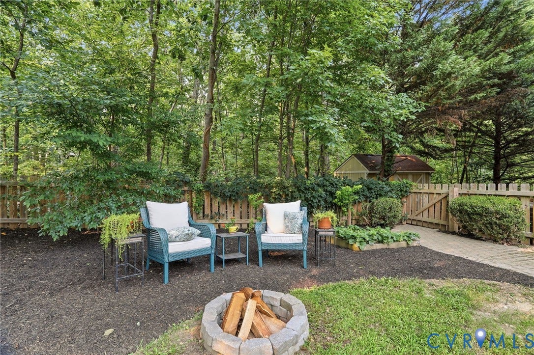 2904 Old Gun Rd W, Old Gun, Midlothian, VA 23113 Backyard retreat featuring a stone fire pit, paver walkway, and wooden privacy fencing