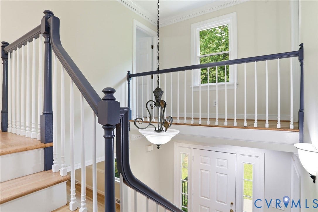 2904 Old Gun Rd W, Old Gun, Midlothian, VA 23113 Two-story entryway featuring a white paneled front door with sidelights, wood-finish flooring, and a decorative chandelier