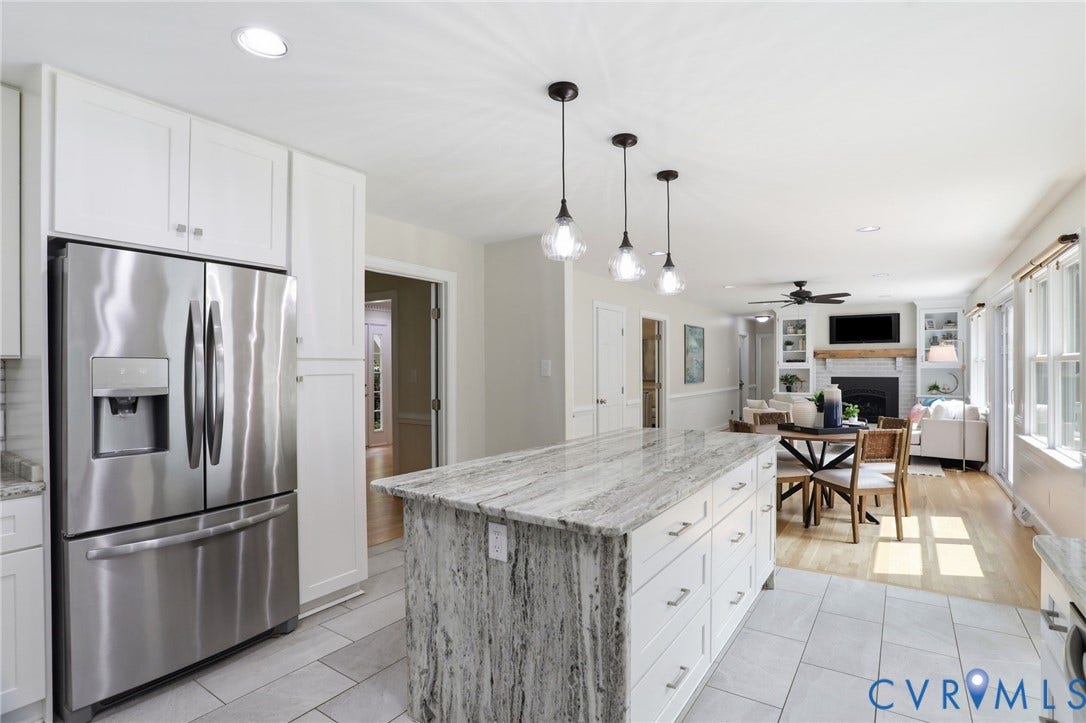 2904 Old Gun Rd W, Old Gun, Midlothian, VA 23113 Open-concept kitchen and living area featuring a central island with a stone countertop, white cabinetry, and stainless steel refrigerator