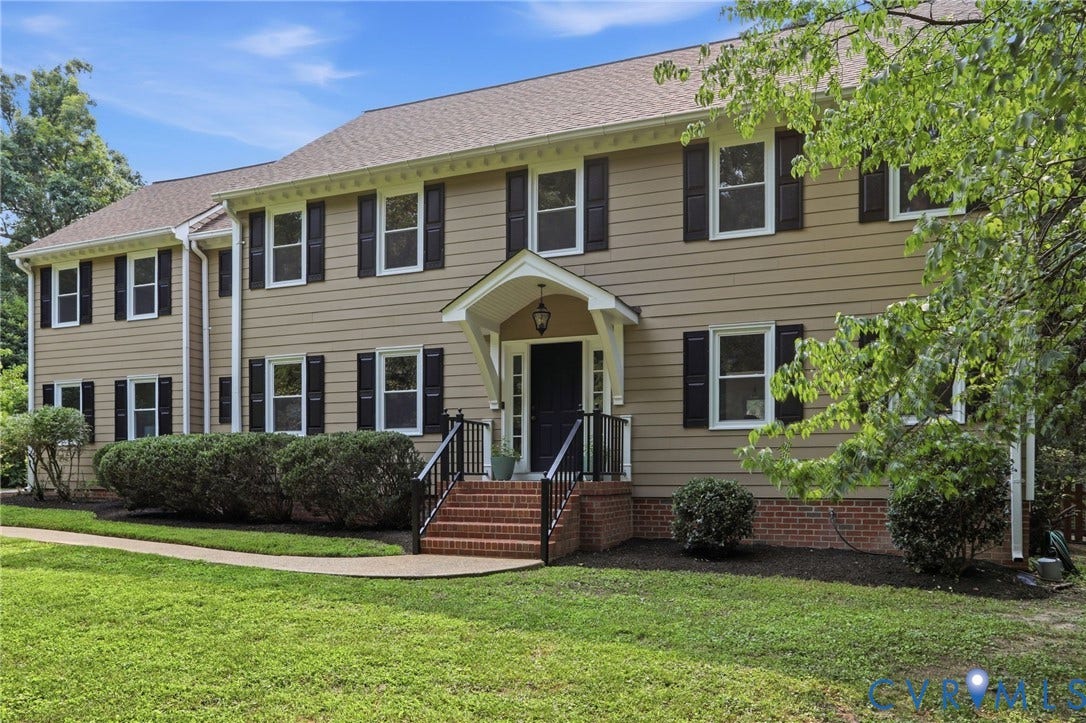 2904 Old Gun Rd W, Old Gun, Midlothian, VA 23113 Traditional two-story residence featuring light brown siding, dark shutters, and a prominent front entrance with a covered porch