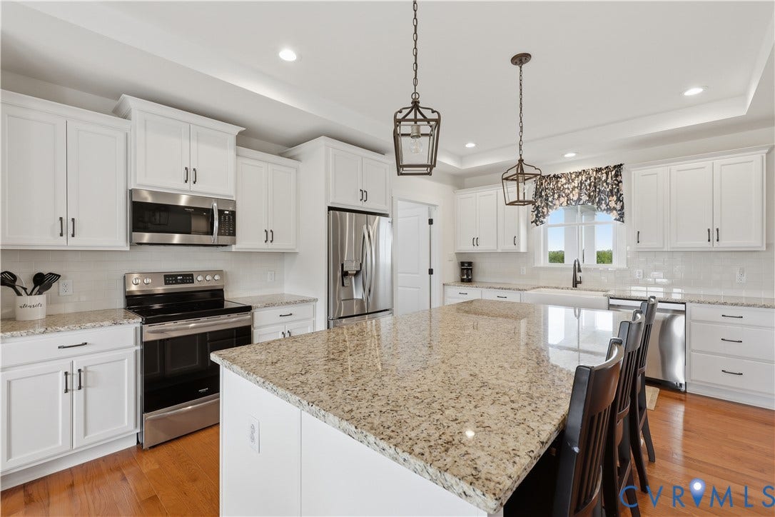 25181 W Soap Stone Rd, Amelia, VA 23083 Spacious kitchen featuring an expansive island with granite countertops, white cabinetry, stainless steel appliances, and wood-finish flooring