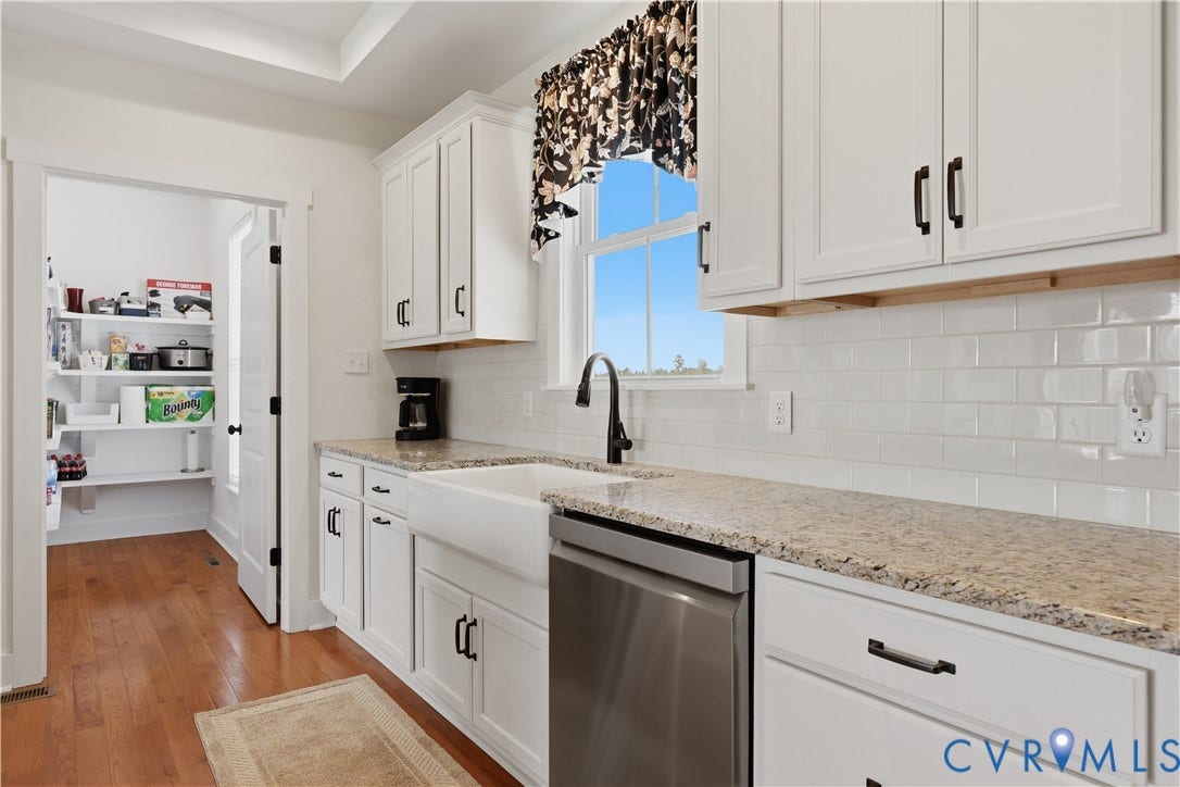 25181 W Soap Stone Rd, Amelia, VA 23083 White shaker cabinetry with black hardware, stone-finish countertops, subway tile backsplash, and stainless steel appliances