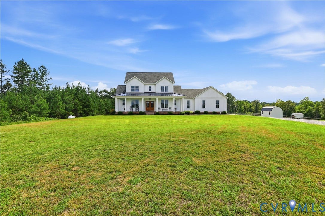 25181 W Soap Stone Rd, Amelia, VA 23083 White two-story residence featuring a covered front porch with columns, dark roof, and a prominent front door