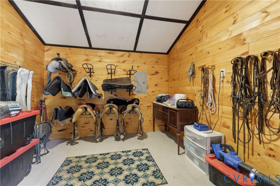 25181 W Soap Stone Rd, Amelia, VA 23083 Wood-paneled room featuring a concrete floor, sloped ceiling with exposed beams, and ample wall storage