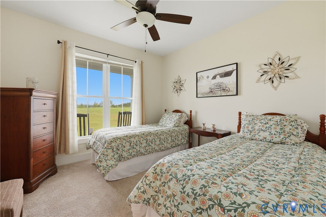25181 W Soap Stone Rd, Amelia, VA 23083 Carpeted room with a large window offering expansive outdoor scenery, neutral wall tones, and a ceiling fan with integrated lighting