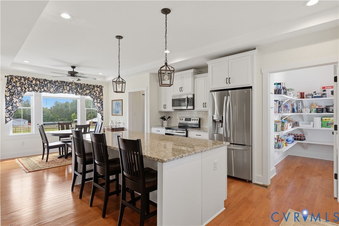 25181 W Soap Stone Rd, Amelia, VA 23083 Kitchen featuring a large island with a stone countertop, white cabinetry, and stainless steel appliances
