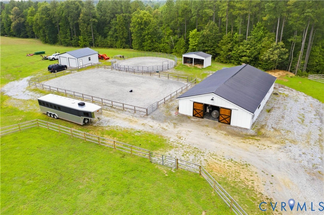 25181 W Soap Stone Rd, Amelia, VA 23083 White barn with a dark metal roof, featuring large wood-finish sliding doors