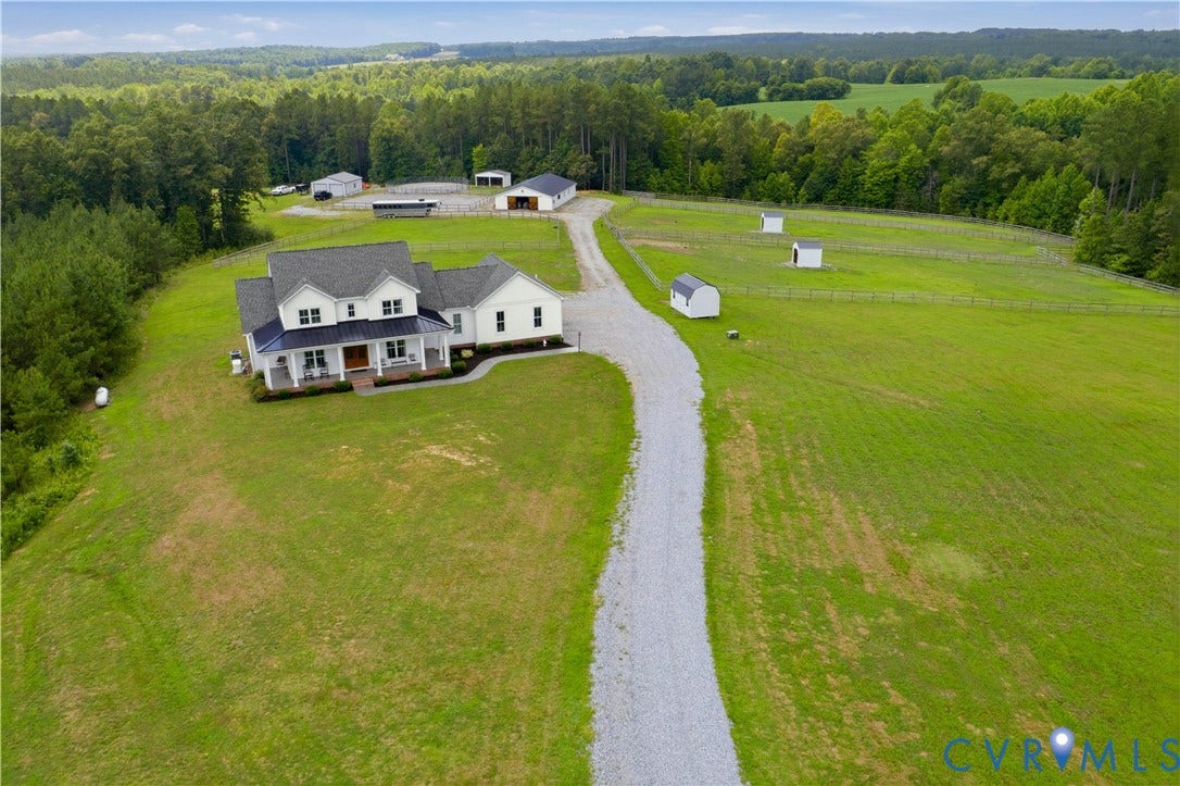 25181 W Soap Stone Rd, Amelia, VA 23083 Expansive property featuring a white residence with a dark roof and a full-width front porch