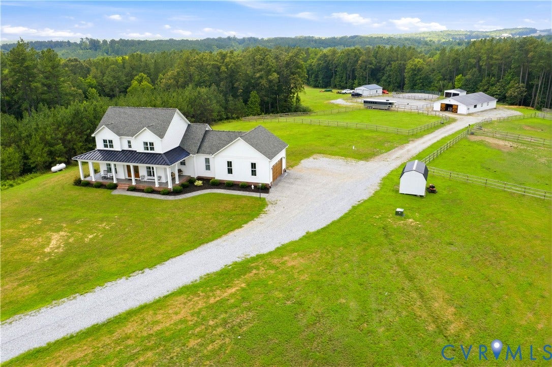 25181 W Soap Stone Rd, Amelia, VA 23083 Expansive property featuring a white two-story residence with a covered porch and attached garage
