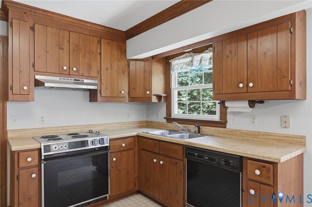 Kitchen with abundant cabinetry, expansive countertops, and a sunny breakfast area overlooking the fenced backyard and pool