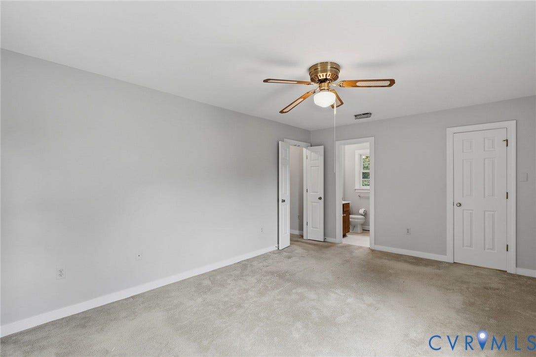 Spacious primary suite featuring fresh paint, a large closet, and a private en-suite bath