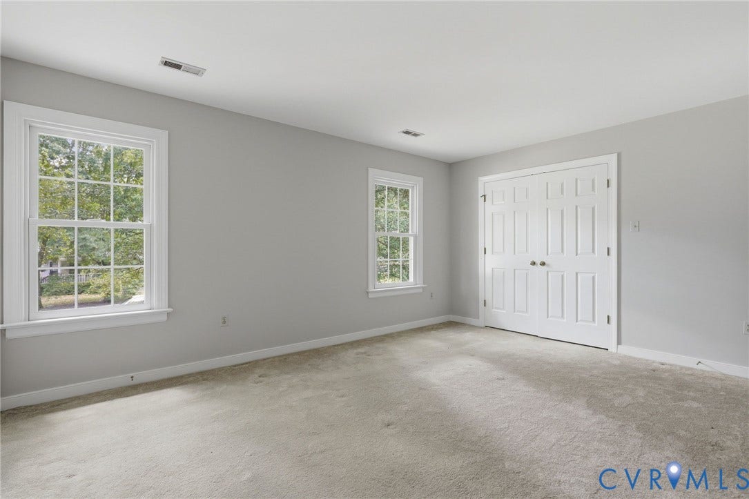 Freshly painted third bedroom featuring abundant natural light, a large closet, and convenient walk-up attic access