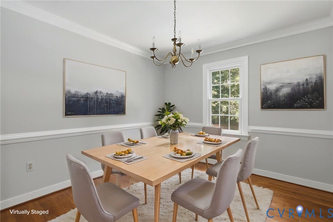 Virtually staged dining room featuring fresh paint, hardwood floors, and crown molding