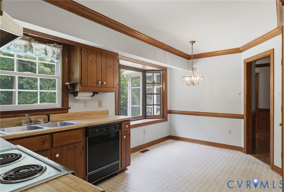 Alternative view of Eat-in kitchen featuring abundant cabinetry, generous counter space, and a large bay window overlooking the backyard and pool.
