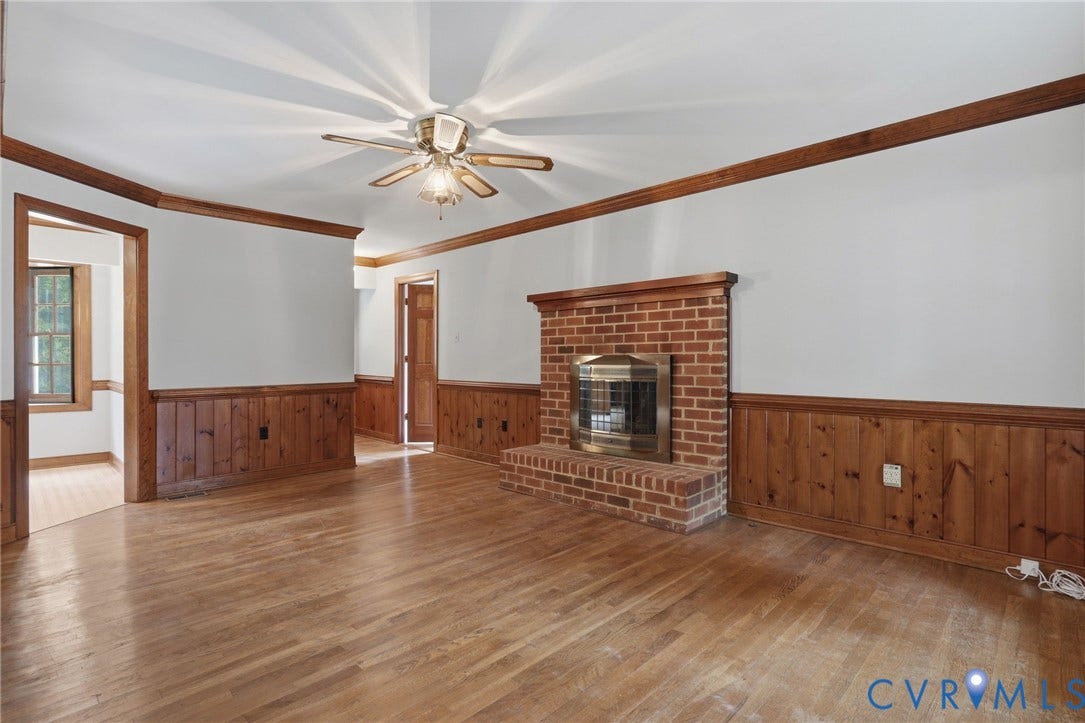 Alternate view of the family room highlighting the open layout, hardwood floors, and easy flow to the adjoining living spaces