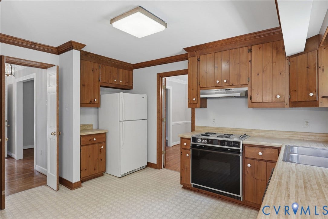 Another view of the eat-in kitchen highlighting plentiful storage, generous work surfaces, and convenient access to the main living areas