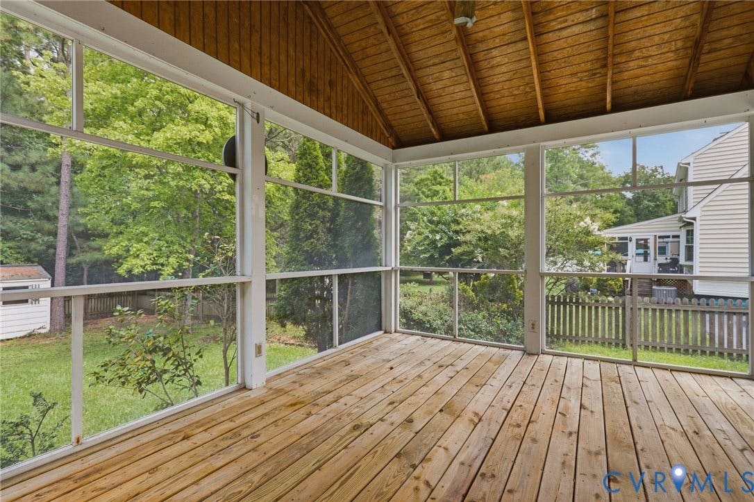 Screened porch featuring skylights and peaceful views overlooking the backyard and pool