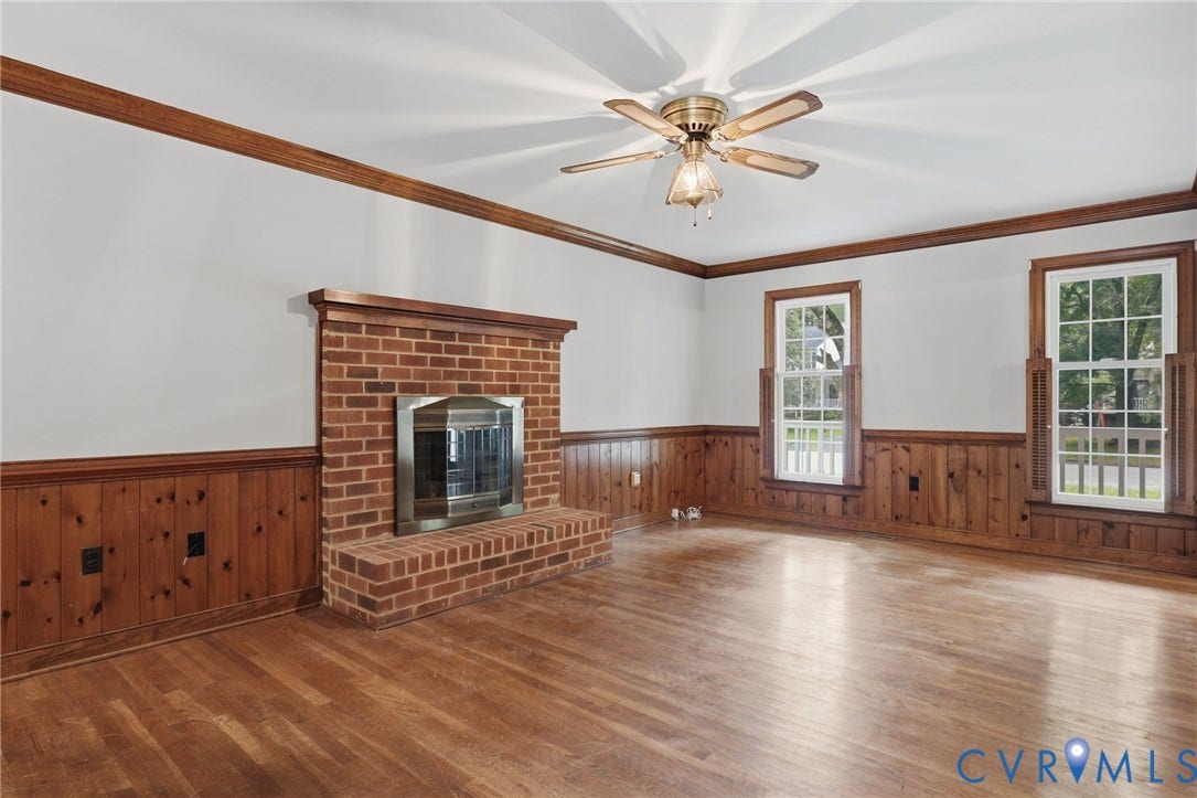 Spacious family room featuring hardwood floors, agas  brick fireplace, and classic wood wainscoting with crown molding.