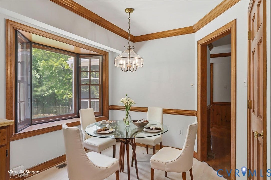 Virtually staged breakfast area featuring a large bay window with backyard views and abundant natural light