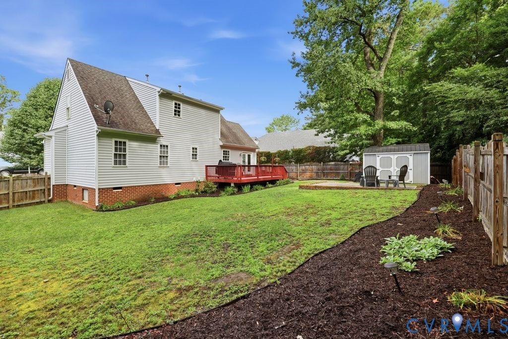 9437 Willow Ridge Drive, Glen Allen, VA 23060 Expansive yard featuring a raised wooden deck, a paved patio, a storage shed, and a privacy fence