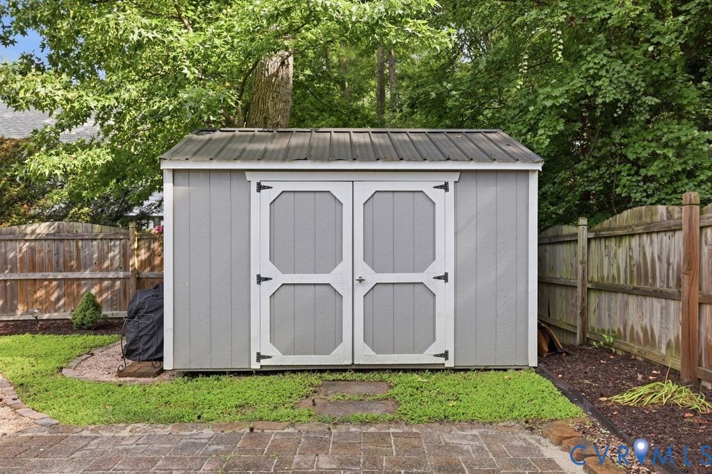 9437 Willow Ridge Drive, Glen Allen, VA 23060 Outdoor shed with double doors, a metal roof, and a wood privacy fence