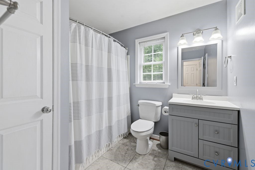 9437 Willow Ridge Drive, Glen Allen, VA 23060 Full bathroom featuring a single window, tiled flooring, a shower with a curved curtain rod, a toilet, and a vanity with a rectangular sink