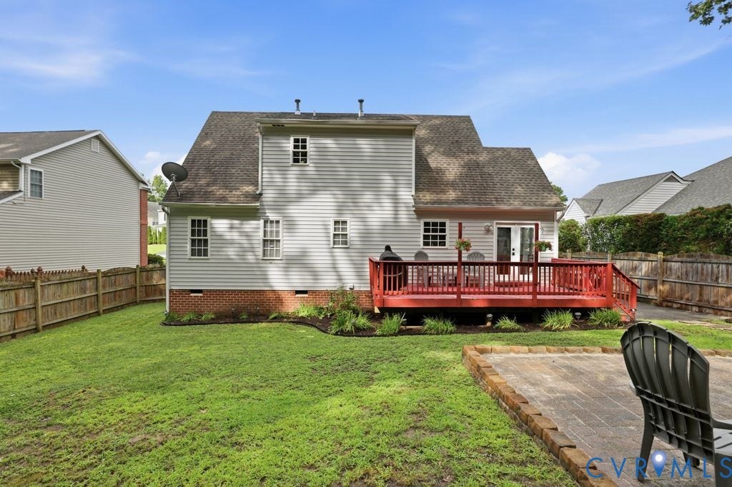 9437 Willow Ridge Drive, Glen Allen, VA 23060 Expansive backyard with a wooden fence, paver patio, and a red-stained wood deck