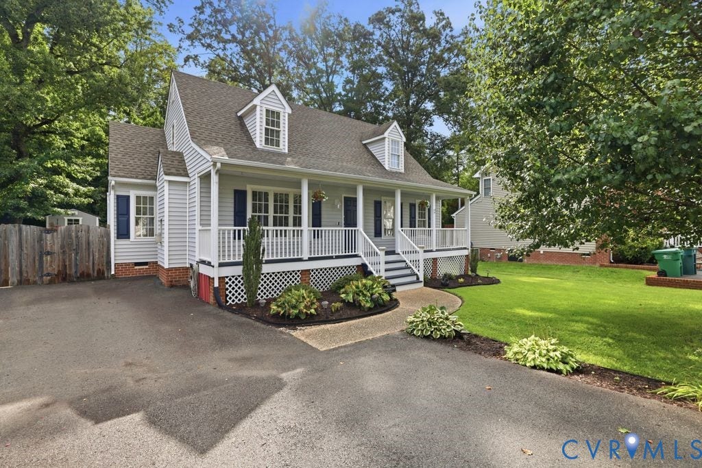 9437 Willow Ridge Drive, Glen Allen, VA 23060 Classic Colonial-style residence featuring white clapboard siding, multiple dormers with arched windows, and a welcoming front porch with white railings and brick foundation
