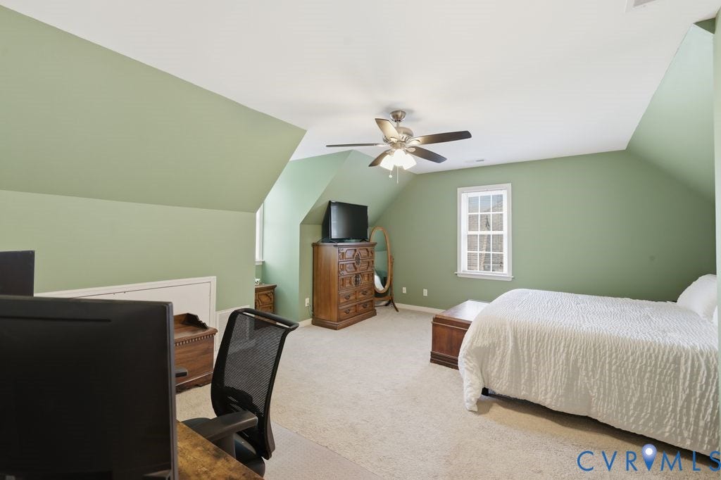9437 Willow Ridge Drive, Glen Allen, VA 23060 Spacious attic bedroom with sloped ceilings, soft green walls, and abundant natural light from dual windows