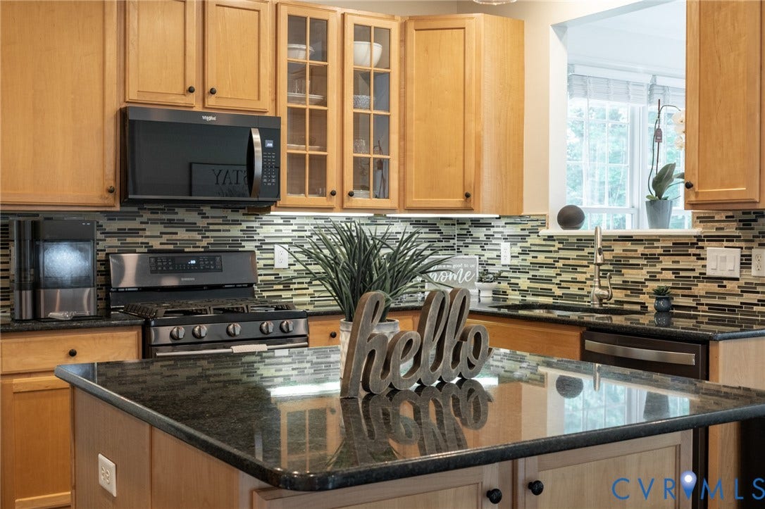4805 Saddleridge Court, Saddleridge At Twin Hickory, Glen Allen, VA 23059 Kitchen featuring a black granite island with light wood-finish cabinetry, black stainless steel appliances, and a mosaic tile backsplash