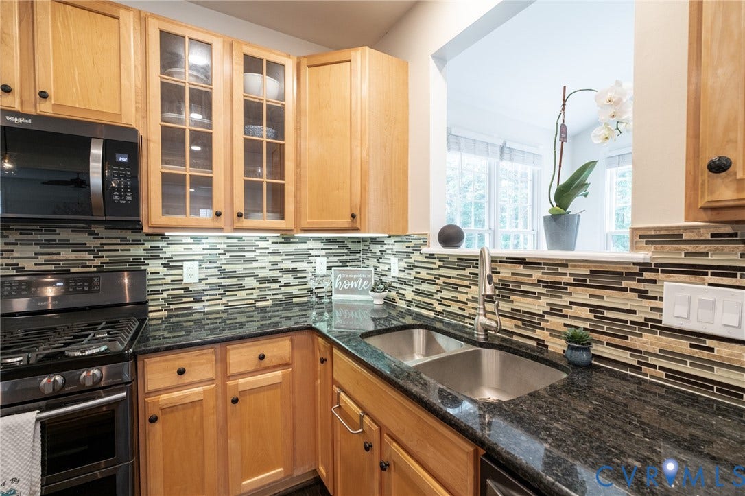 4805 Saddleridge Court, Saddleridge At Twin Hickory, Glen Allen, VA 23059 Kitchen featuring wood cabinetry, dark speckled countertops, and a mosaic tile backsplash