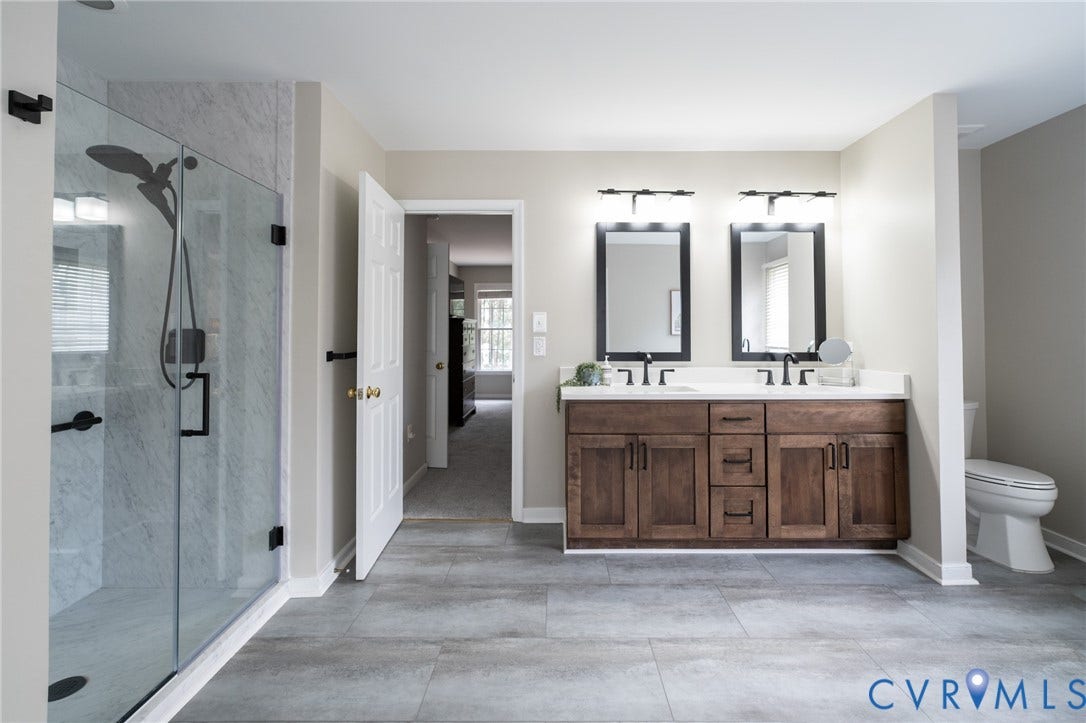 4805 Saddleridge Court, Saddleridge At Twin Hickory, Glen Allen, VA 23059 Spacious primary bathroom featuring a double vanity with dark wood cabinetry and white countertops, two framed mirrors, and a glass-enclosed shower with tile surround