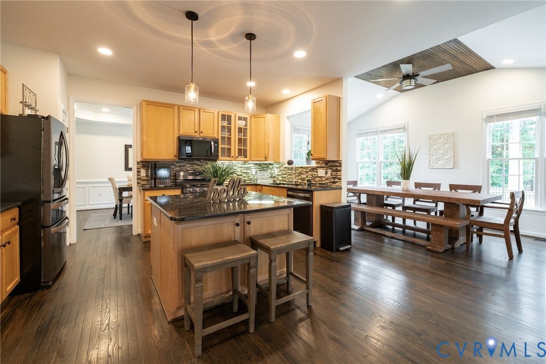 4805 Saddleridge Court, Saddleridge At Twin Hickory, Glen Allen, VA 23059 Open-concept kitchen and dining area featuring dark wood flooring, a kitchen island with pendant lighting, black appliances, a tiled backsplash, and recessed lighting