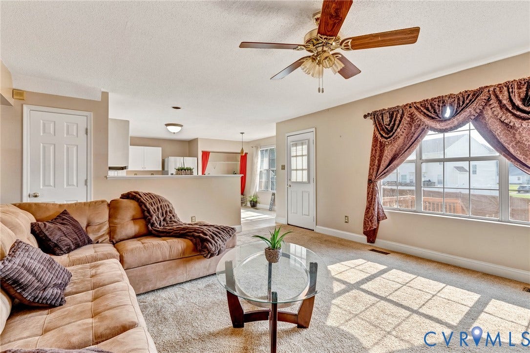 1601 Varina Station Court, Henrico, VA 23231 Carpeted living area with overhead ceiling fan, a large window, and an exterior access door